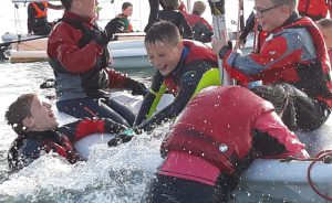 Children having fun on a dinghy during youth course